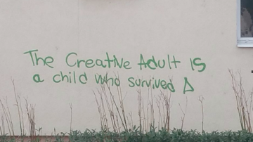 Graffiti saying 'the creative adult is a child who survived'