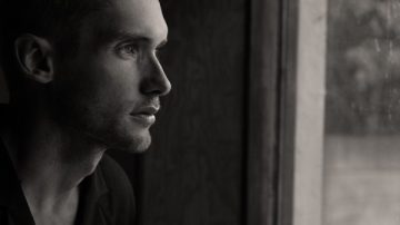 Man looking through window