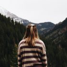 lady stood in front of mountains as if looking towards a journey