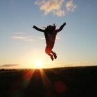 Person jumping in the air in front of sunrise
