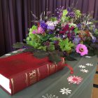 coffin with flowers and bible on top