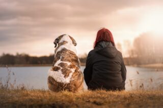 Woman and her dog by a river