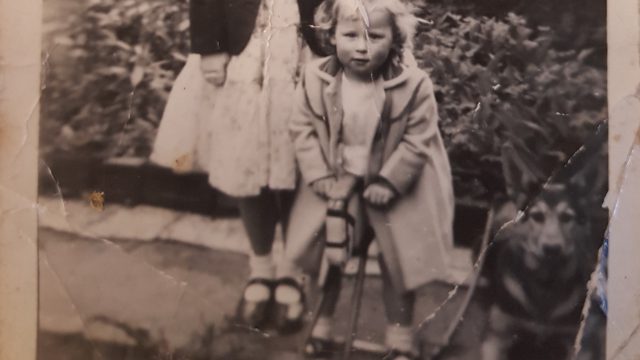 old black and white photo of a little girl and her Alsatian