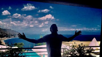 young man standing on a balcony on holiday