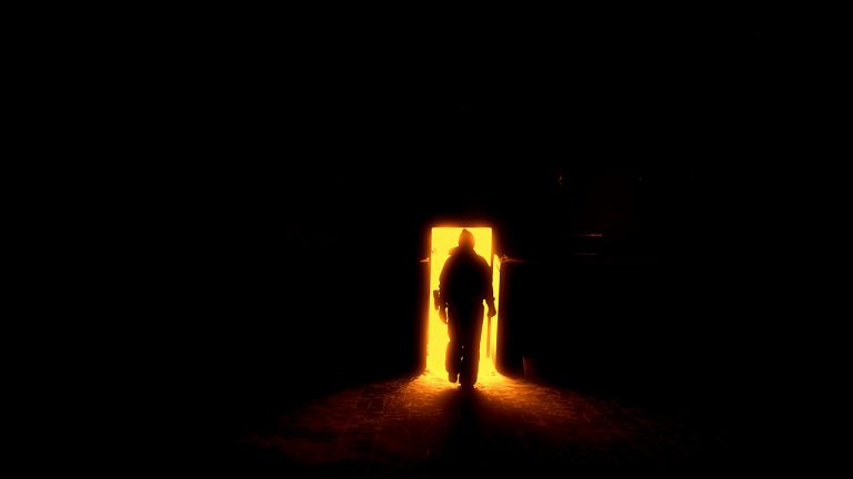 Someone walking into a lighted door