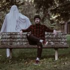 ghost stood behind a man on a bench