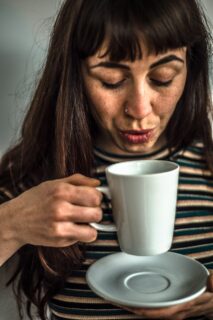 woman blowing on a hot drink